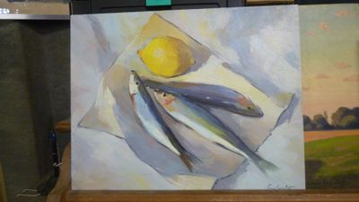 un tableau représentant des poissons posés sur une table, avec un citron dessus