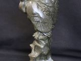 statue of an angel holding a bird on a rock