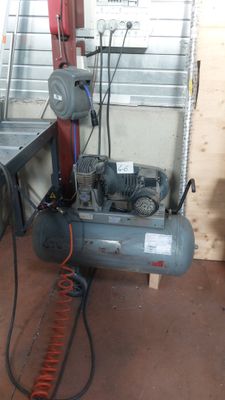 deux compresseurs d'air dans un garage, avec une échelle
