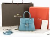 a blue purse and a red box on the table