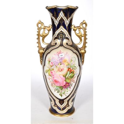 un vase avec des fleurs peintes dessus, posé sur une table