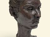 sculpture représentant la tête d'une femme sur un socle, sur fond blanc
