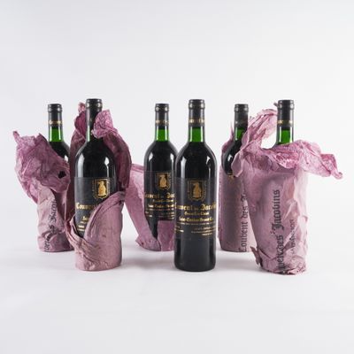 trois bouteilles de vin posées les unes à côté des autres sur une surface blanche
