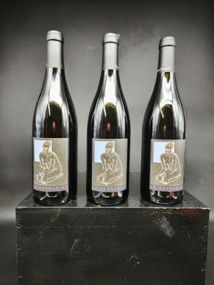 trois bouteilles de vin posées sur un bloc de bois