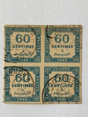 quatre vieux timbres-poste sur un bout de papier attaché par une ficelle