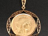 un pendentif en forme de pièce d'or, avec le visage d'une femme au centre