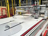 a machine that is cutting a sheet of paper in a factory