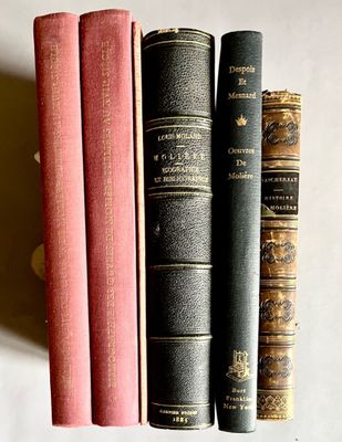 plusieurs vieux livres sont alignés sur une étagère