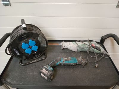 un chariot noir avec des outils posés dessus, dans une pièce