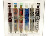 five watches in a clear display case on a white background