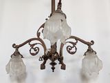 a chandelier with three glass shades hanging from it