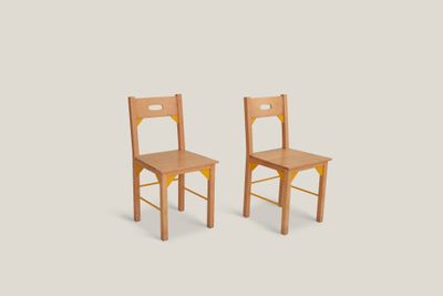 deux chaises en bois placées côte à côte sur un fond blanc