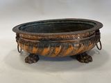 an old metal bowl with a handle on a white surface