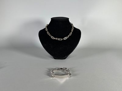 two pieces of jewelry sitting on top of a table next to each other
