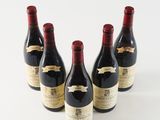 four bottles of wine are lined up in a row on a white surface