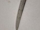a close up of a knife on a white surface on a table