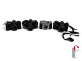 three cameras sitting next to each other on a white surface