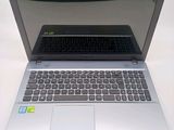 a silver laptop with a black keyboard on a white table