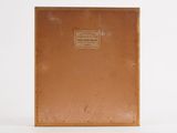 an old book with a brown cover sitting on top of a white surface