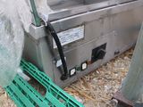 a machine that is sitting on the ground next to a green crate