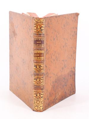 un vieux livre posé sur une table blanche à côté d'un mur blanc