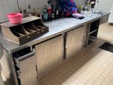 une femme debout devant un plan de travail dans une cuisine