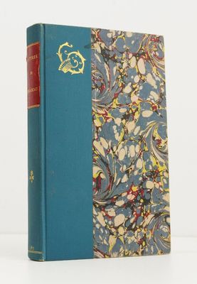 un vieux livre posé sur une table blanche, à côté d'un livre bleu