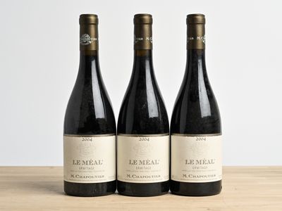 trois bouteilles de vin posées sur une table en bois