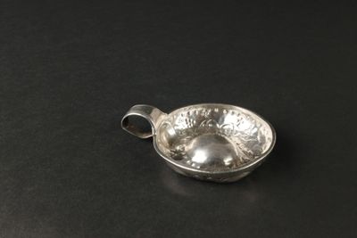 un petit bol en argent posé sur une table noire