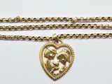 a gold necklace with a heart shaped pendant on a chain