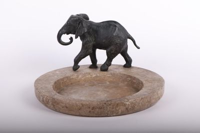 statue d'un éléphant posée sur un socle en pierre, sur fond blanc