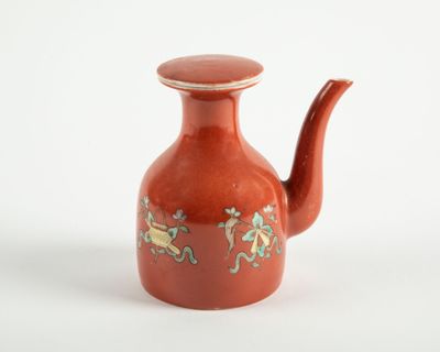 une petite théière rouge décorée d'un motif