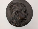 une image représentant un médaillon en bronze à l'effigie d'une femme