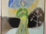 un tableau représentant une femme avec un parapluie, posé sur un chevalet