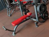 a gym room with a red wall and a red bench