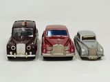 four toy cars are lined up in a row on a white surface