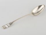 an antique silver spoon with a handle on a white surface