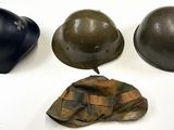 three helmets and a hat are sitting on a white surface