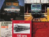 plusieurs livres posés sur une table, avec un train en arrière-plan