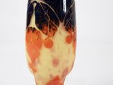 a vase that is sitting on a stand on a white surface