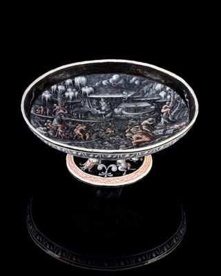 une assiette ancienne en argent avec un fond noir et un fond noir