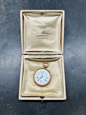 une petite montre de poche en or à l'intérieur d'un écrin en or