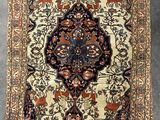 an antique persian rug with a floral design on a grey background