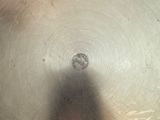 a shadow of a person standing in front of a metal bowl