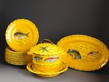 several yellow plates with fish painted on them sitting on a table