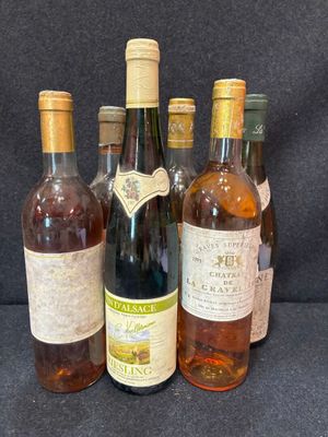 Plusieurs bouteilles de vin sont alignées sur un fond noir