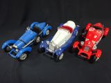 three toy cars sitting next to each other on a black background