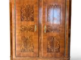 a wooden cabinet with carvings on the doors