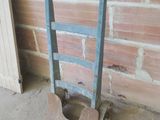 une pelle appuyée contre un mur de briques, à côté d'une cheminée