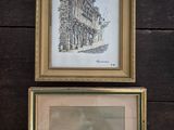 two framed pictures of a building and a boat on a wooden wall